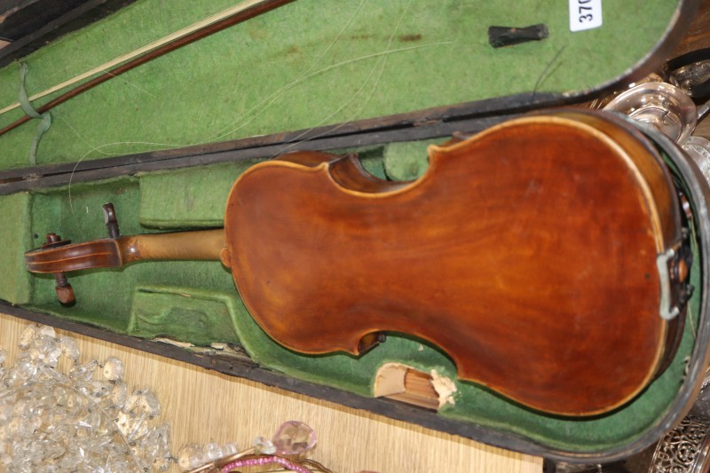 An early 20th century Saxon violin cased with bow and a cased banjo